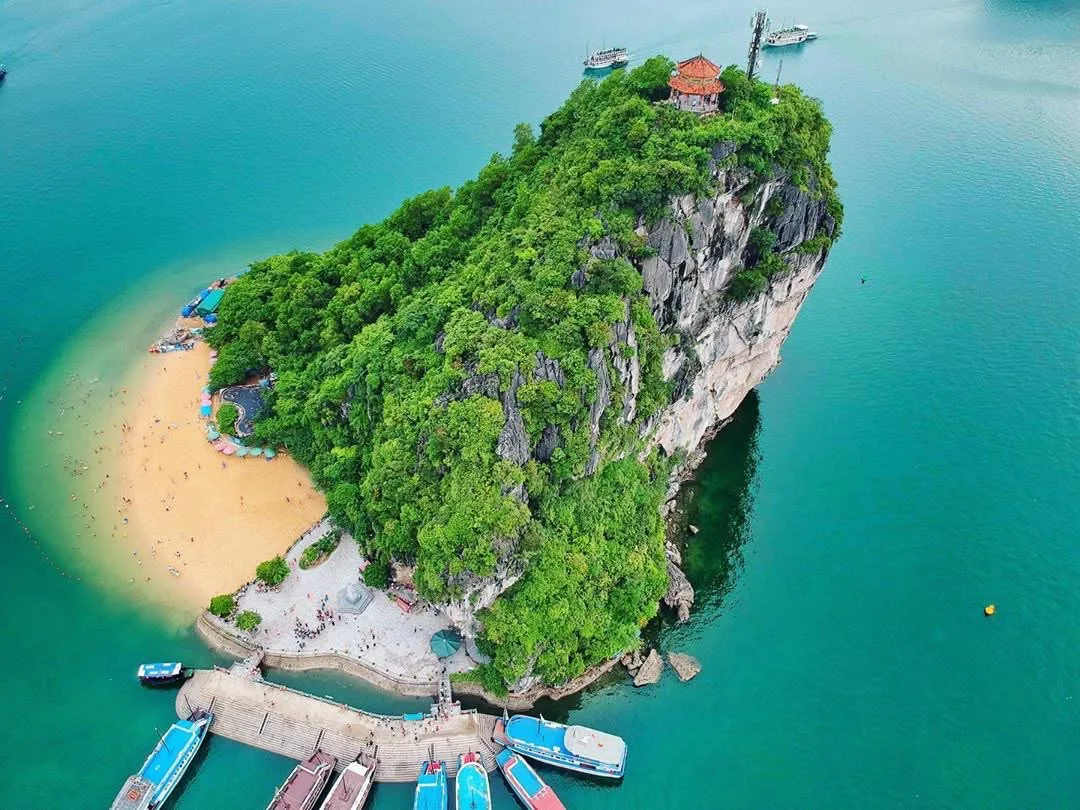 A cruise ship navigating through Halong Bay with a clear sky, illustrating ideal conditions
