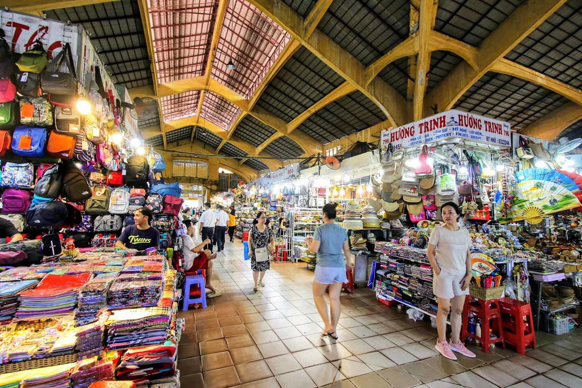 A lively Ho Chi Minh City night market street scene with food stalls and shoppers