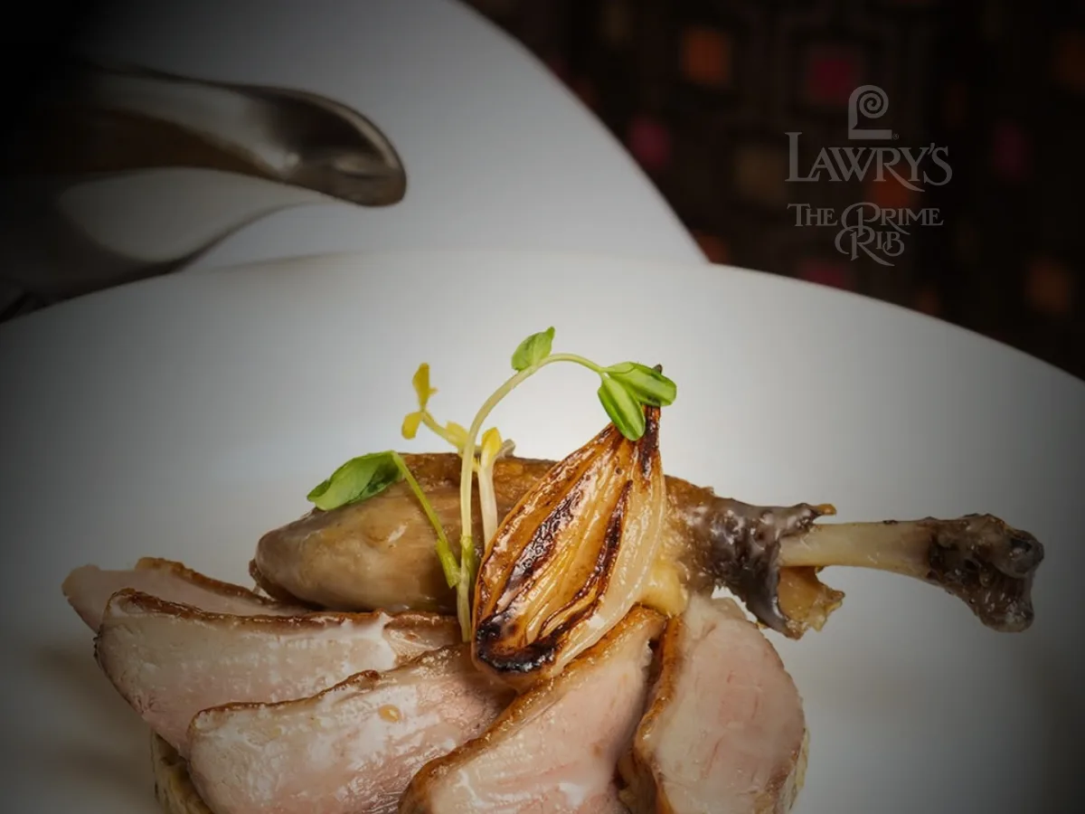 Crispy duck confit plated with garnish and sauce