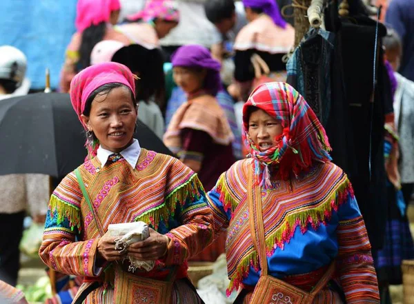 Flower Hmong women in colorful traditional attire at Bac Ha Market.